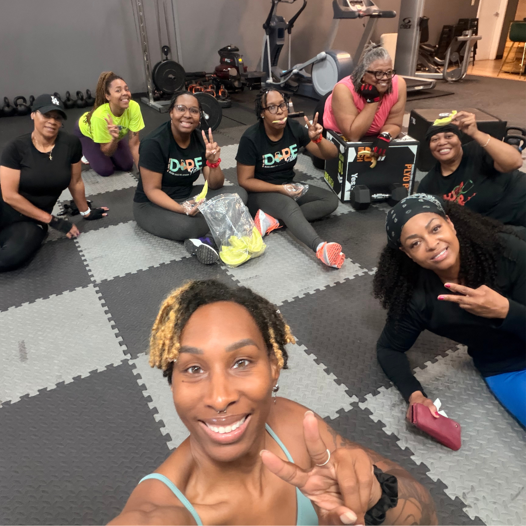 ReleaseHER Fit Club members relaxing together on the gym floor